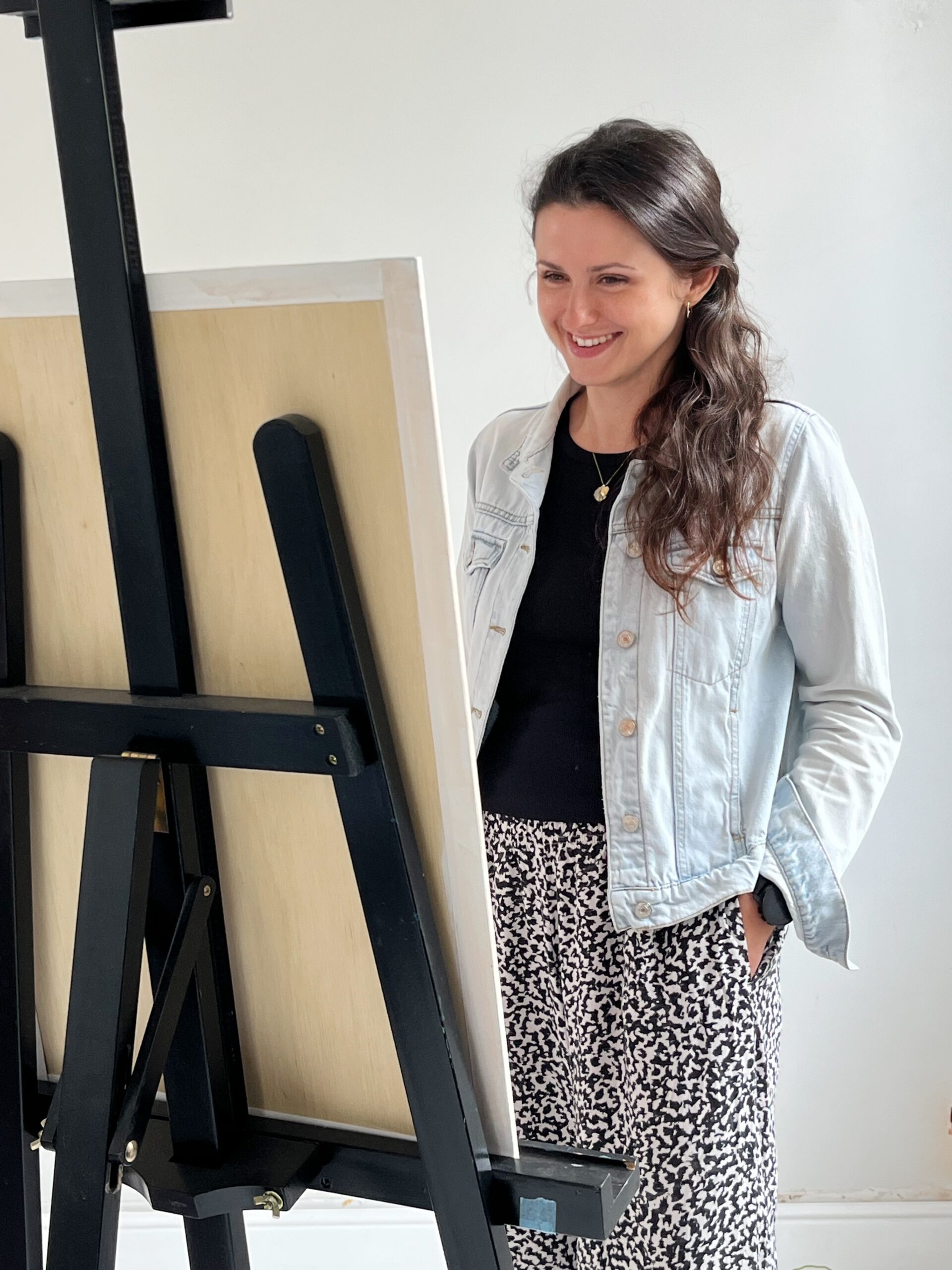 "Izabela O., psychotherapist, standing by a custom artwork in progress"