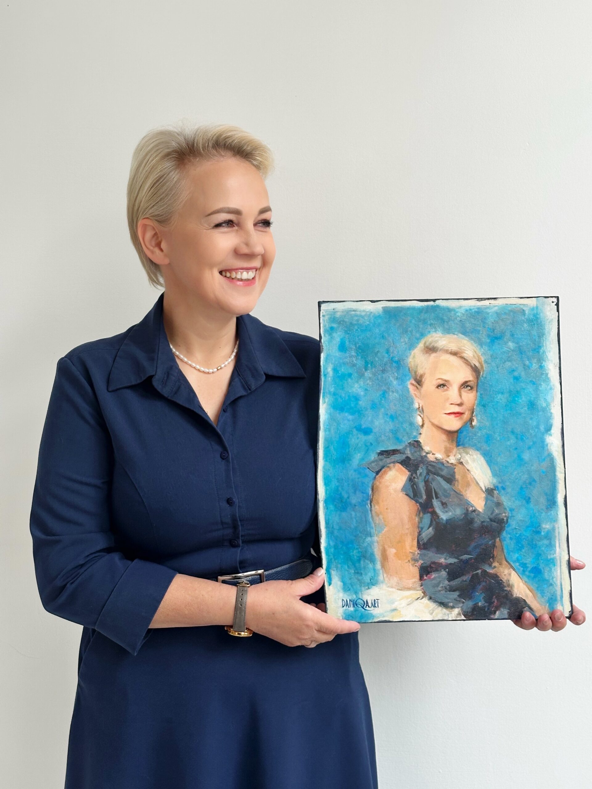 "Beata M., CEO, holding a hand-painted luxury portrait from Daniqa" Beata trzyma swój prezent - ręcznie malowany portret Daniqa,